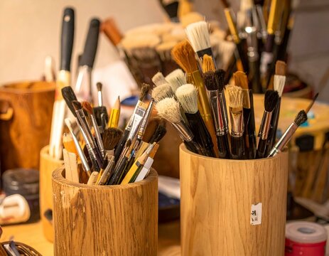 Wooden Holders Filled with Paintbrushes and Pencils.  A collection of art supplies ready for creative work.