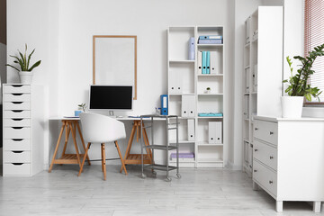 Interior of medical office with doctor's workplace and shelf units