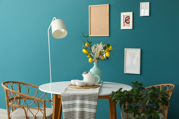 Interior of room with dining table, lamp and frames
