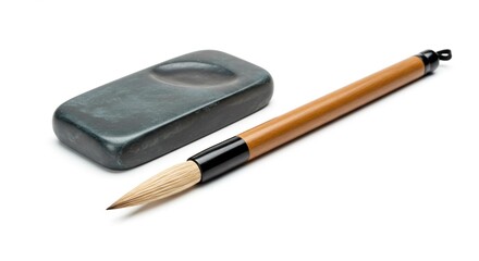 A calligraphy brush and inkstone resting on a white surface in a studio setting for artistic work