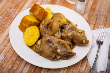 Delicious stewed pig trotters served with potatoes on white plate