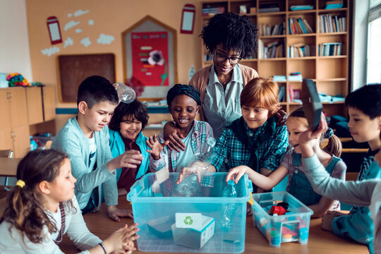 Elementary school kids learning recycling with teacher in classroom activity