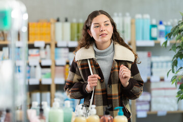 Portrait of girl in winter clothes shopper choosing some products in a supermarket