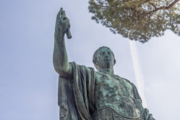 Imperial figure stands tall against a bright blue sky in a historic public square