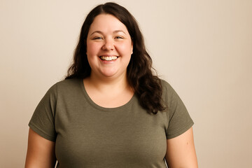 Fototapeta premium Smiling plus-size woman in green t-shirt against beige background