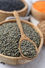 Different types of lentils on light table, closeup