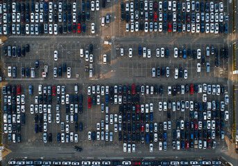 An aerial shot shows many cars neatly parked in a large parking lot, showcasing organization.