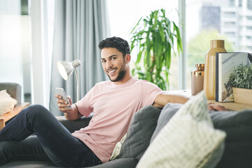 Happy man, portrait and relax with phone on sofa for online research, social media or browsing web...