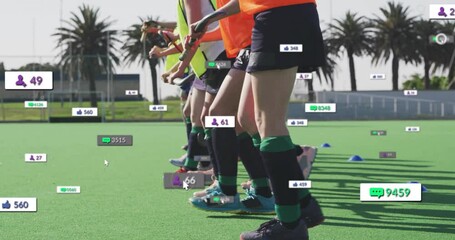 Female athletes practicing field hockey training on turf, showing floating social media icons - Powered by Adobe