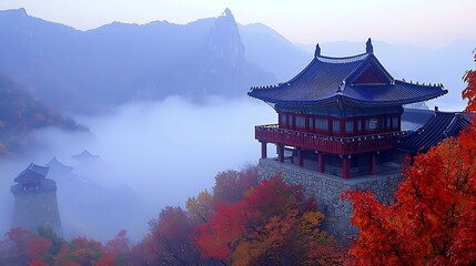 Obraz premium Misty mountaintop temple with autumn foliage.