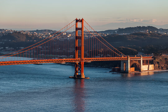 Golden Gate Bridge stands prominently at sunset overlooking San Francisco Bay - Powered by Adobe