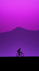 Obraz premium Silhouette of cyclist on a mountain road at sunset