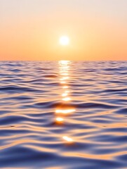 Serene sunset over calm ocean; sun's reflection creates a shimmering path on the water's surface