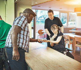 Help, community and disability with a man serving a woman in a wheelchair in a health center for learning and development. Care, support and volunteer with a male caregiver working in a soup kitchen