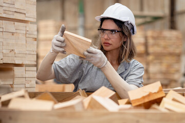 Team engineer carpenter wearing safety uniform and hard hat working holding wood piece checking quality of wooden products at workshop manufacturing. female worker wood warehouse industry.