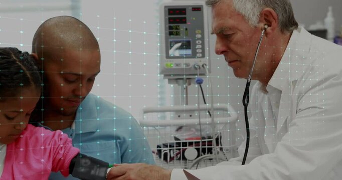 Doctor examining child with father supporting arm BP cuff for health checkup showing ECG waveform
