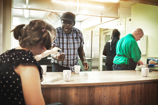 Disability home, care and people with down syndrome help with kitchen cooking to improve motor skill. Disabled patient group doing brain and balance support training helping the community cafeteria - Powered by Adobe