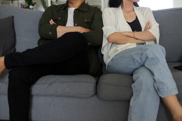 Man and woman stressed for argument sitting on sofa at home