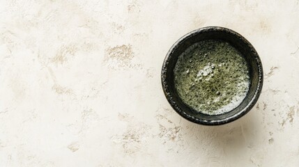 Small dark bowl of matcha tea