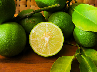Close up of fresh lime with leaves, whole and half, green limes, natural, fruit