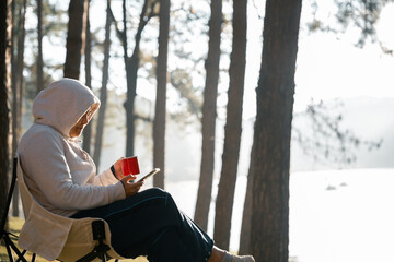 Remote work technology online close up communication smart phone laptop telephone digital travel brown nature sunlight camp beverage morning sit drink coffee tent orange outlying concept background.