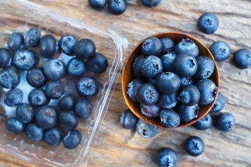 Blueberries in wood bowl on wooden table background