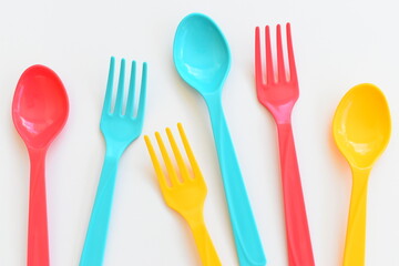 colorful spoon and fork isolated on white background, plastic cutlery for picnic