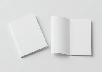 Two plain books one closed and one open on a simple isolated on gray background