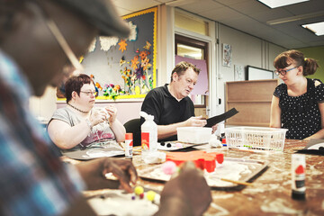 Disability health care art workshop, creative paint and down syndrome people doing a project....