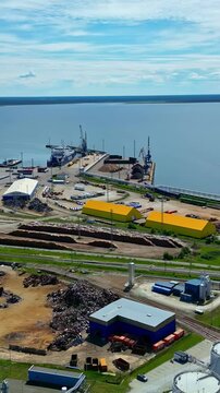 Aerial shot of industrial waterfront with a blue seascape in background.