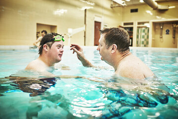 Pool, disability and down syndrome man in swimming class for exercise, mental and physical...