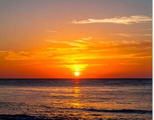 Fototapeta premium Fiery sunset over calm ocean. Golden hour colors paint the sky and sea.