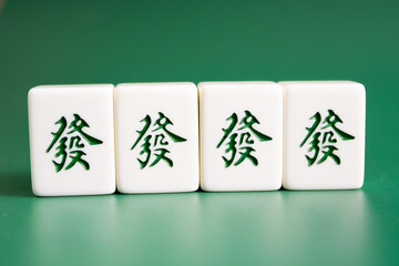 Close-up of mahjong tiles on a green surface,Mahjong (mah jongg, mah-jongg, and mahjongg) is a tile-based game that was developed in the 19th century in China