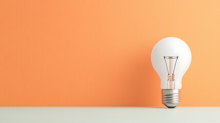 Single lightbulb against a plain orange background