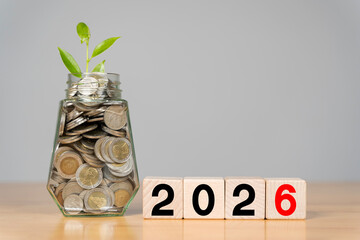 Business and new year concept 2026. Word 2026 written on white cube or block with coins in bottle.