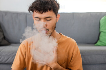 Man coughing while smoking a cigarette at home