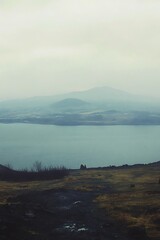 Serene Icelandic vista featuring water, mountains and misty atmosphere