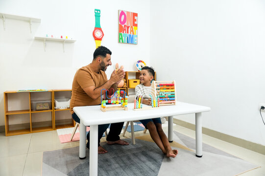 Happy Middle Eastern Dad Applauding To His Little Son During Playing Educational Wooden Toys