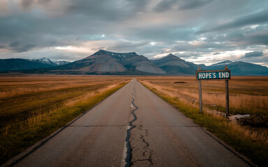 Road to Hope's End A Remote Highway Leading to Distant Mountains Under a Dramatic Sky