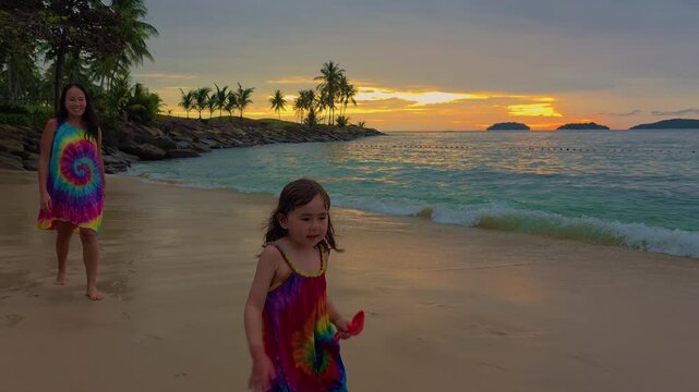 Mother And Daughter Wearing A Rainbow Dress Outfit On A Tropical Beach At Sunset In Kota Kinabalu, Sabah, Malaysia. Slow Motion Shot