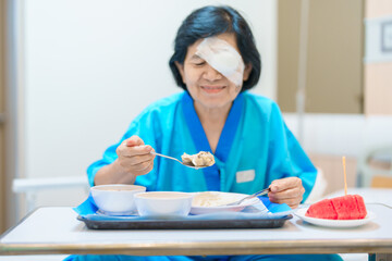 Senior Woman eating food after eye surgery in hospital . Eye disease, Cataract,  Glaucoma, Age...