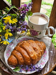 Croissant with coffee and milk on wooden background