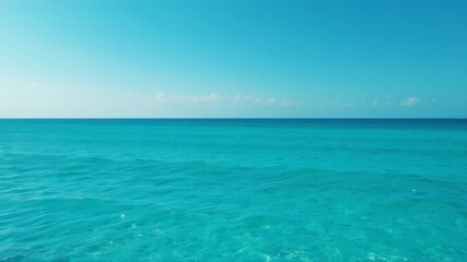 Fototapeta premium A breathtaking view of a tranquil turquoise ocean under a vibrant blue sky on a sunny day.