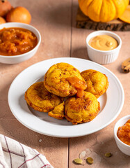 Traditional Chilean sopaipillas (fried pumpkin fritters) served with pebre (spicy salsa) or chancaca (sugarcane syrup), a popular snack.