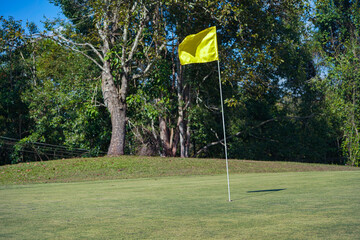 Background of evening golf course has sunlight shining down at golf course.
