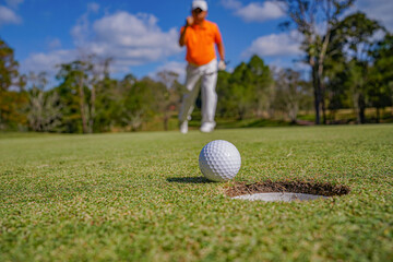 Golfer playing golf in the evening golf course, on sun set evening time.