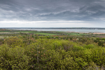 Dramatic sky over spring meadow and distant lake