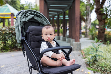 Infant sitting quietly in stroller at city park