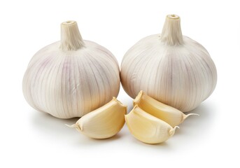 Two whole garlic bulbs with cloves isolated on a white surface in a studio lighting setting