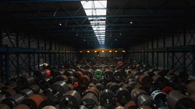 Beautiful aerial of a large warehouse filled with steel coils and a large overhead crane